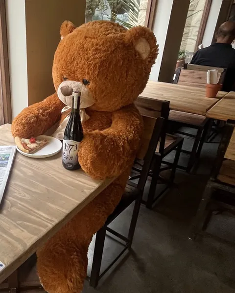 El osito de Lobito, sentado a la mesa junto a la ventana